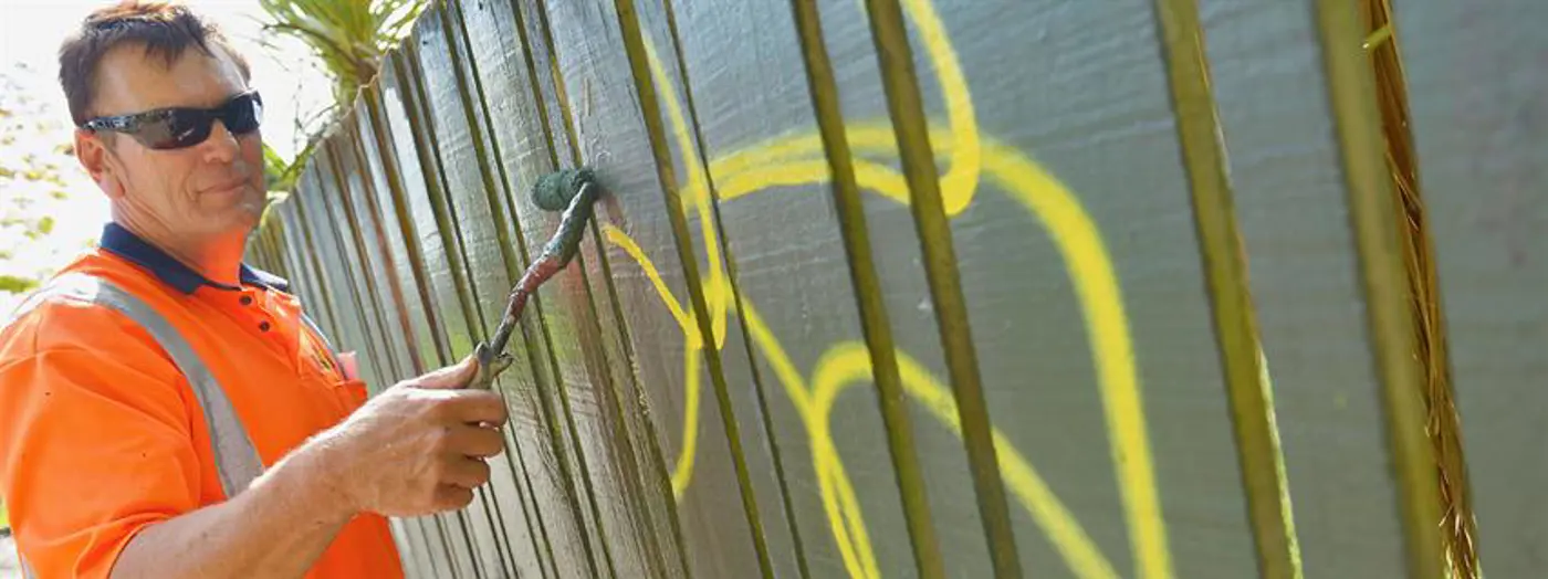 a person painting a fence