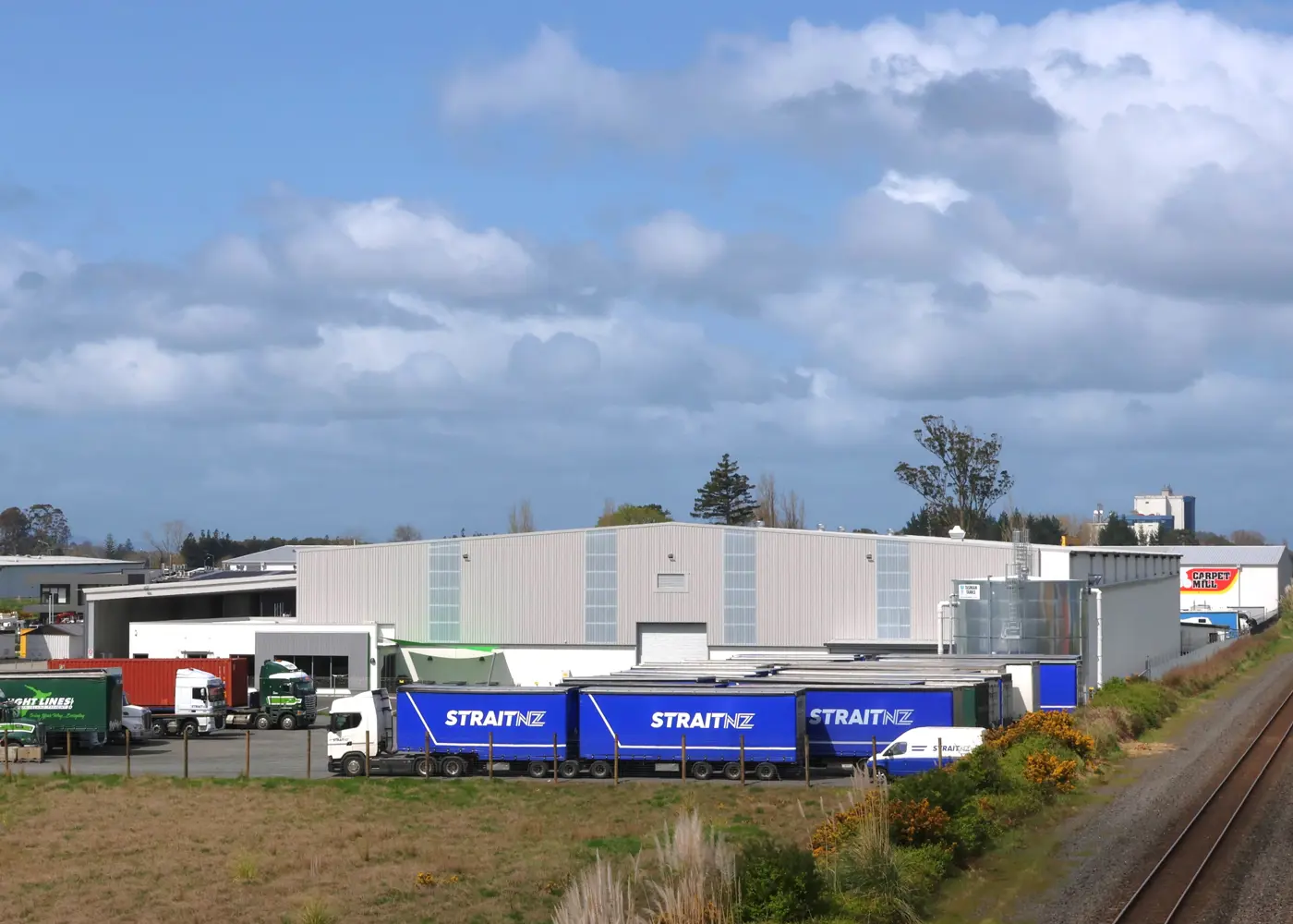 a large warehouse with trucks parked in front of it