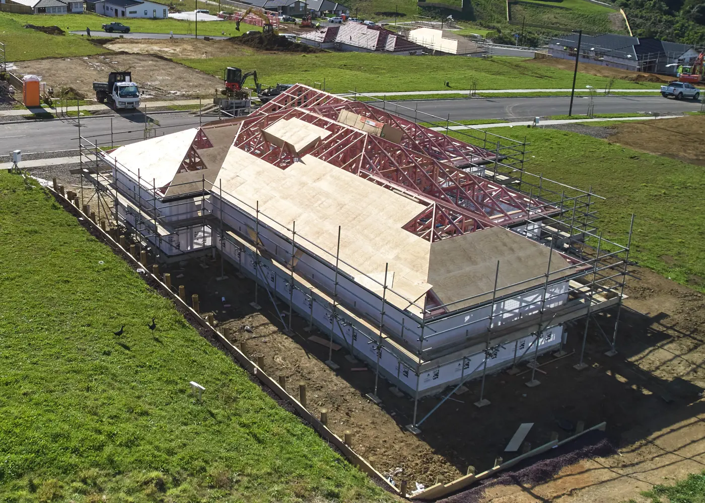 a building under construction with a green field and grass