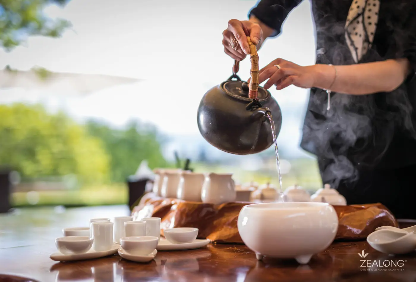 a person pouring water into a teapot