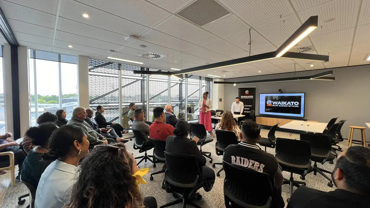 a woman standing in front of a group of people in a room