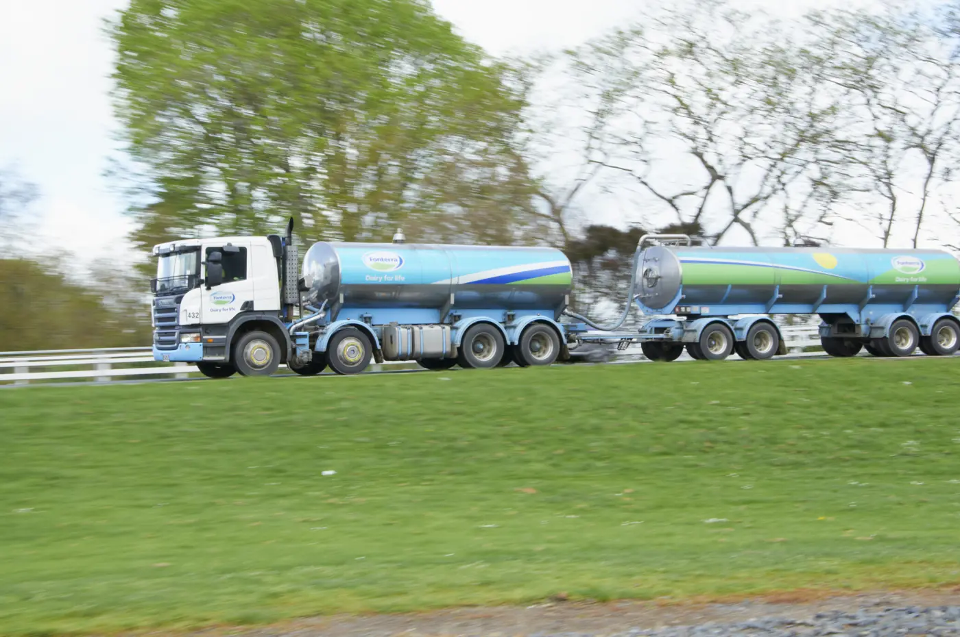 a truck with a tank trailer on the side of the road