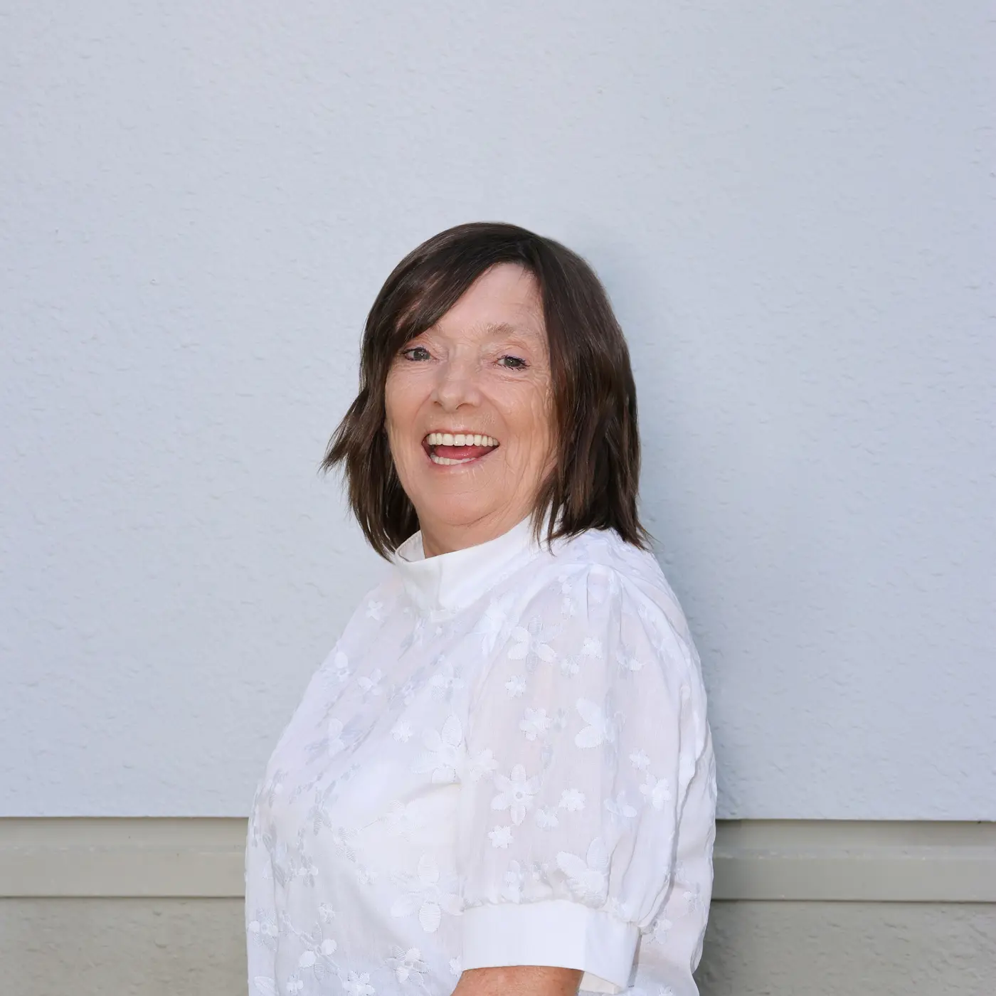 a woman smiling in a white shirt