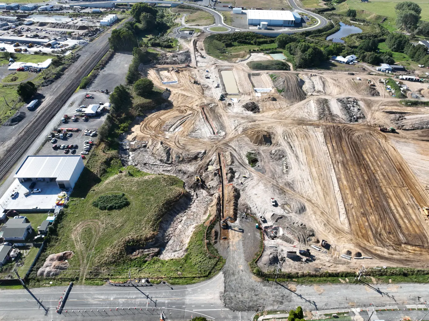 an aerial view of a land with a road and buildings