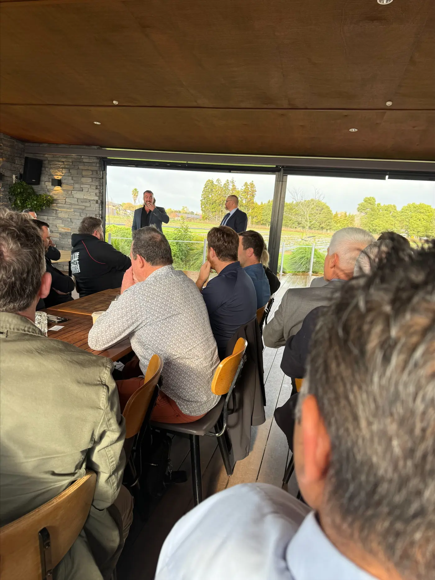 a man speaking into a microphone in front of a group of people