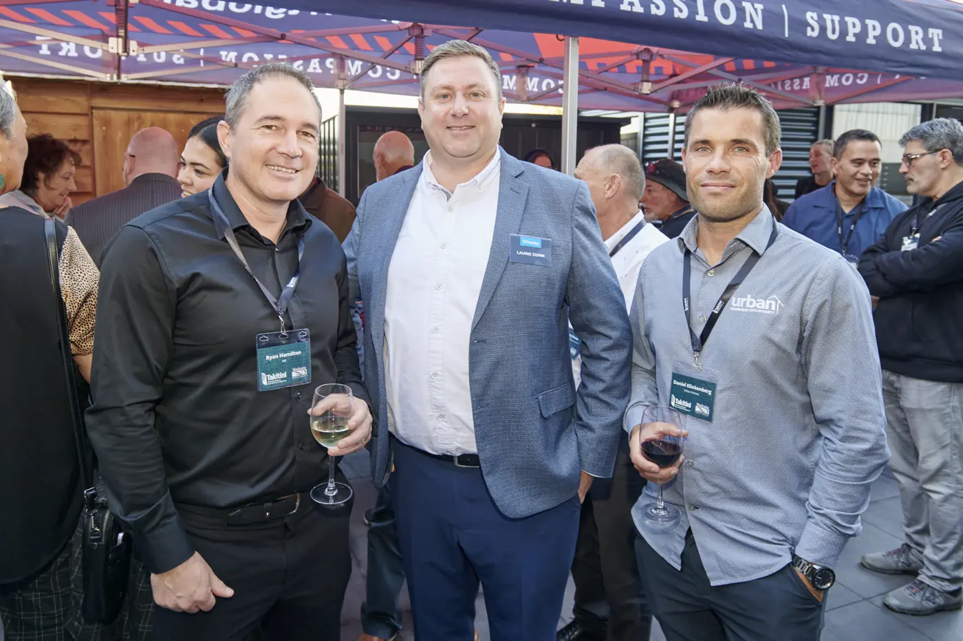 a group of men standing together with wine glasses