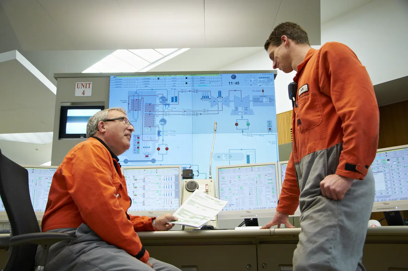 a man in orange jumpsuits looking at a paper