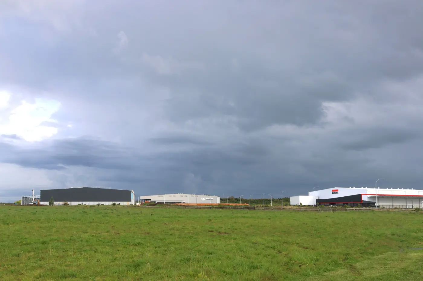 a field of grass with buildings in the distance