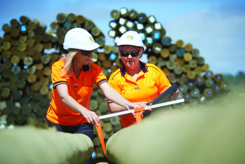 a group of women wearing hard hats and looking at a ruler