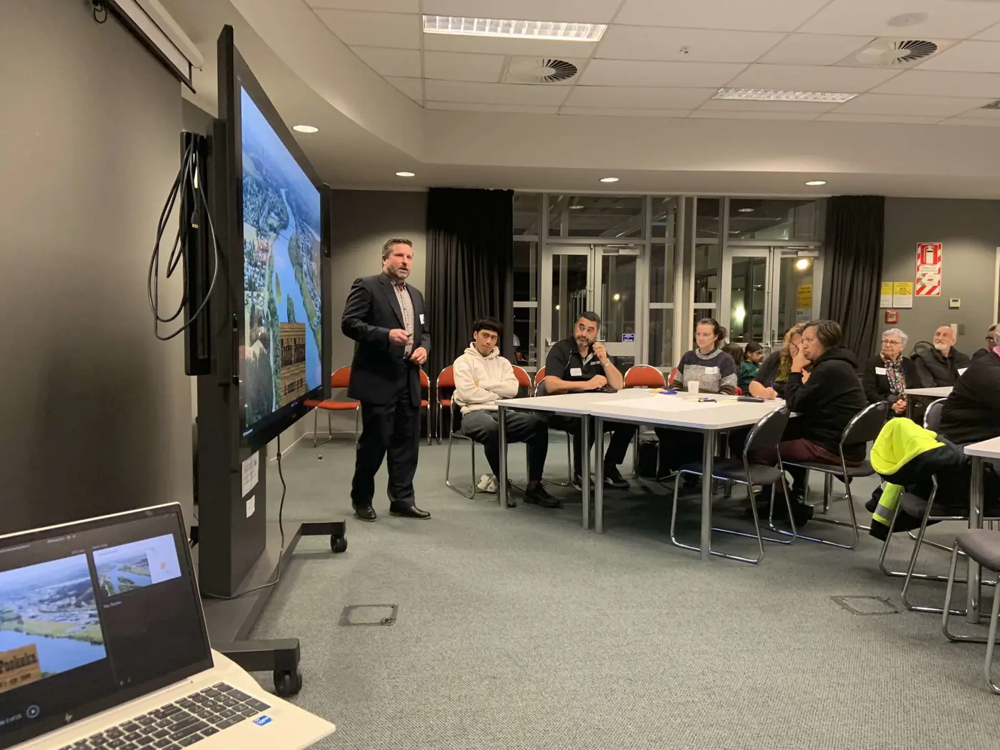 a man standing in front of a large screen