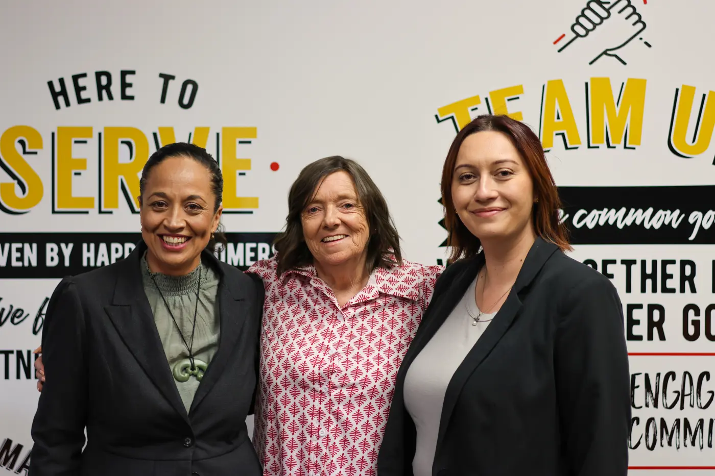 a group of women standing together smiling